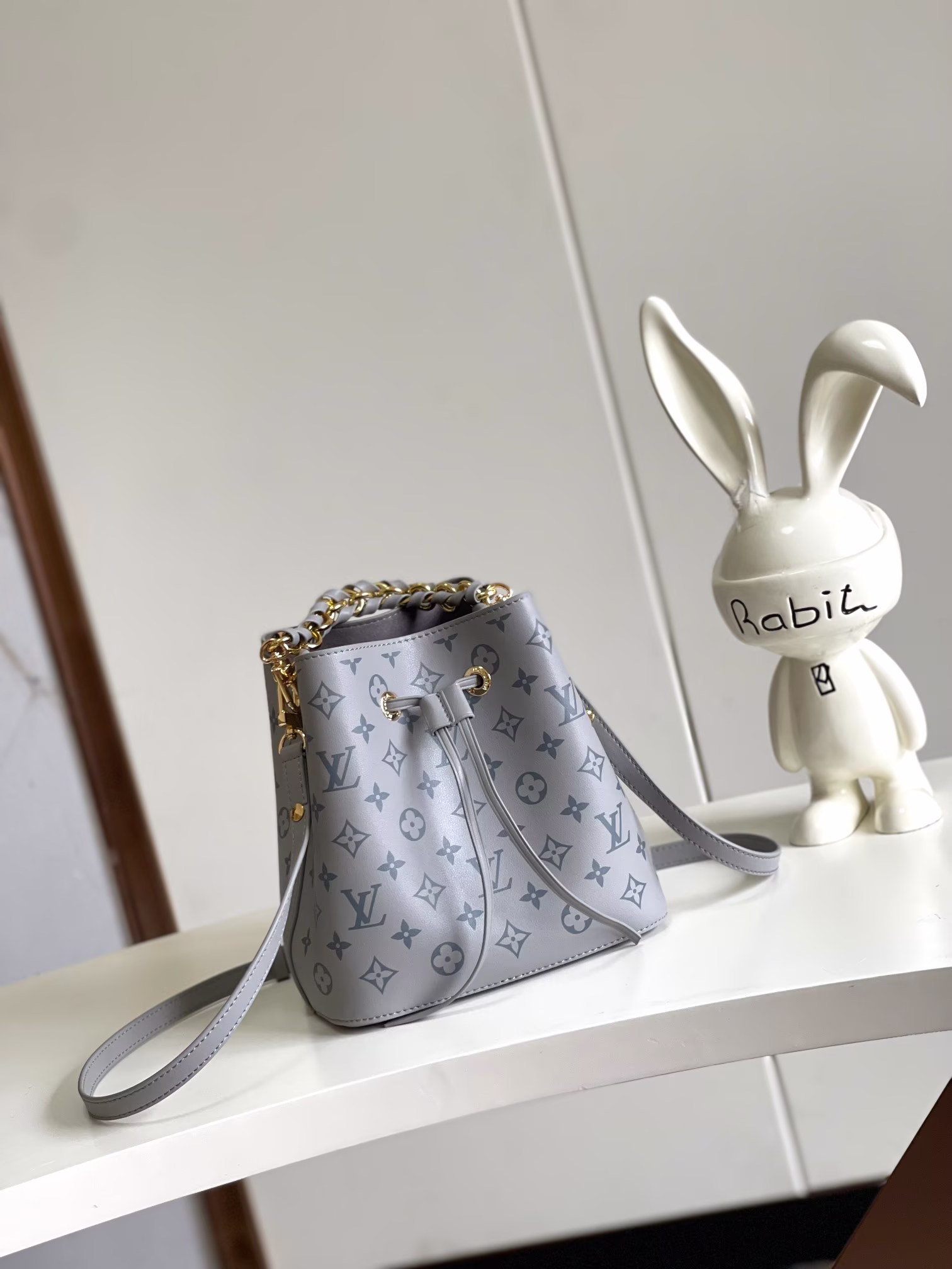 P1100 M45716 Gray Floral M12749 This Néonoé BB bag is crafted in the brand's new Monogram Ink leather with a classic print that brightens up the collection, while the simplicity of the bag is modernized by the woven chain and the dazzling metal pieces that lend an air of elegance to the bag. The interior pocket is designed to securely hold your valuables 20 x 20 x 13 cm (L x H x W).