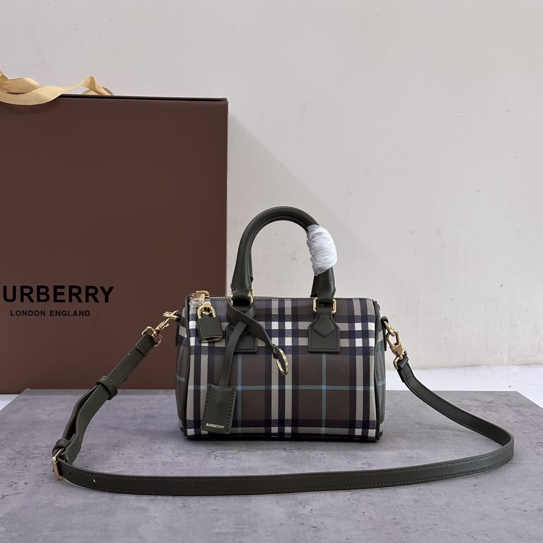P1020 Burberry Mini Pillow Bag, stand-up design with Burberry check pattern, leather wrapped padlock and luggage tag 18.5 x 11 x 12 cm. Leather top handle. Detachable and adjustable shoulder strap. Zipper closure; hand-painted lacquered edges. Glossy metal hardware. Leather covered padlock. Luggage tag. Luggage tag with Burberry letter-embossed logo.