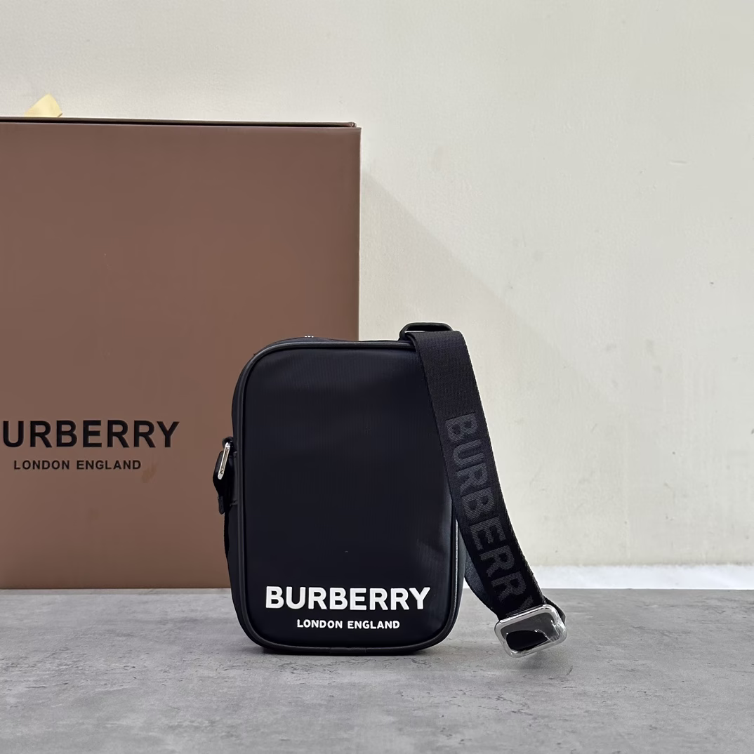 P700 Berberi Vertical Paddy Bag Slim style, made in Italy of worsted nylon fabric 12 x 4.5 x 17.5cm.Adjustable slash strap.3 card slots.1 external slip pocket. Zipper closure. Hand-painted edges. Glossy metal hardware. 3D embossed Burberry letter logo on front.