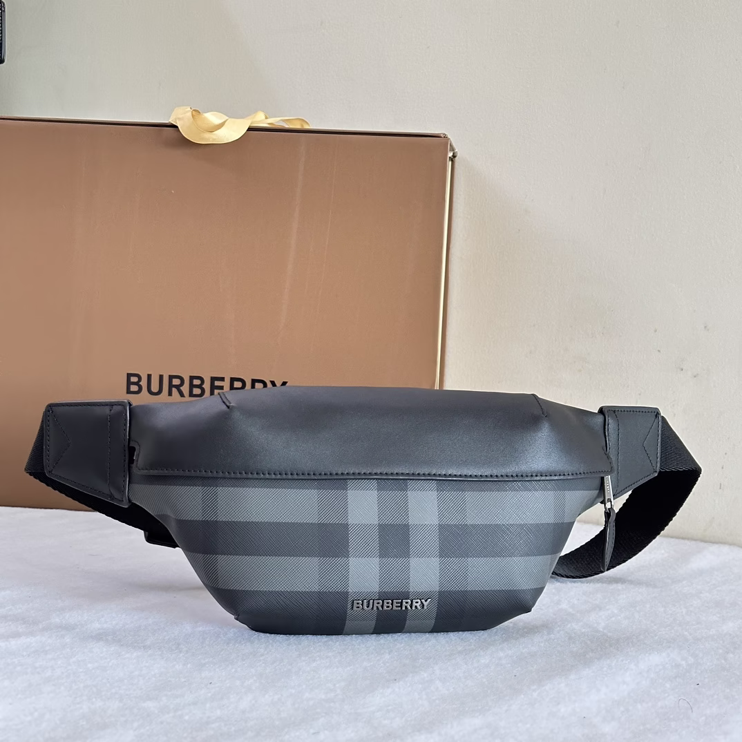 P880 Burberry 90s street style waist bag, made of brand charcoal grey checkered cotton fabric, with leather decorative elements. It can be worn cross-body or tied at the waist with a shoulder strap. The main material of this boutique is at least 30% from bio-based materials. Bio-based materials are mainly derived from renewable natural resources such as plants and castor oil. 31 x 7.5 x 16cm adjustable buckle strap. 1 outer zipper back pocket; 1 patchwork inner pocket. Zipper opening and closing. Hand-painted painted edges. Glossy metal accessories - high imitation bag