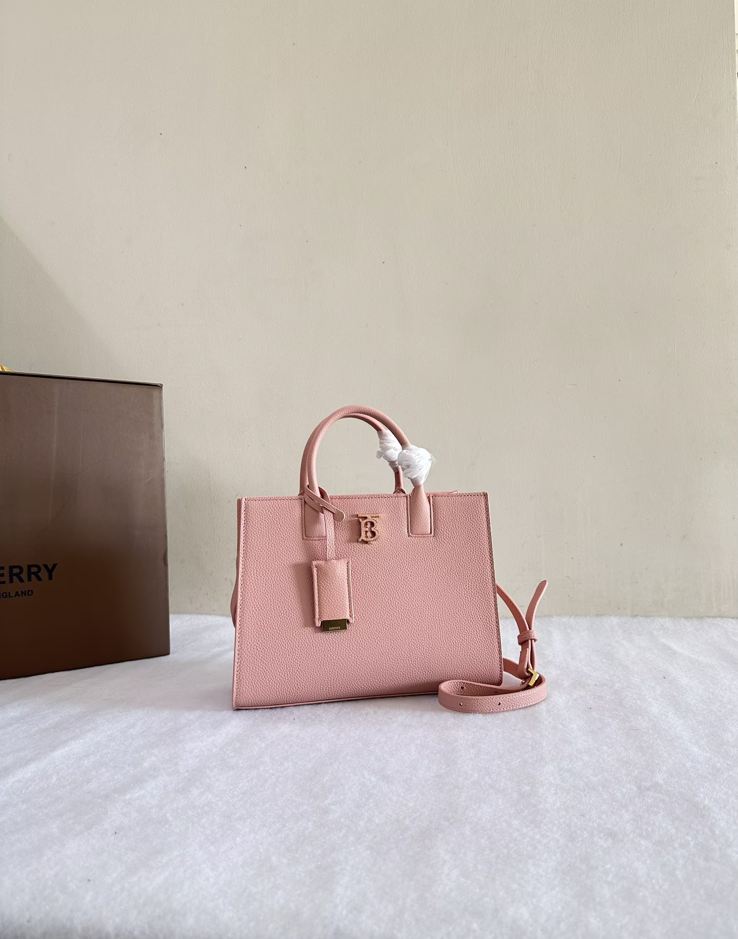 P1220 Burberry minimalist tote bag in grained leather with Thomas Burberry logo 27 x 11 x 20cm top leather handles. Detachable and adjustable shoulder strap. 1 external slit pocket, 1 internal slit pocket and 1 zipped internal pocket. Open mouth with magnetic snap closure. Hand-painted edges. Glossy metal hardware. Leather-covered mirror charm.