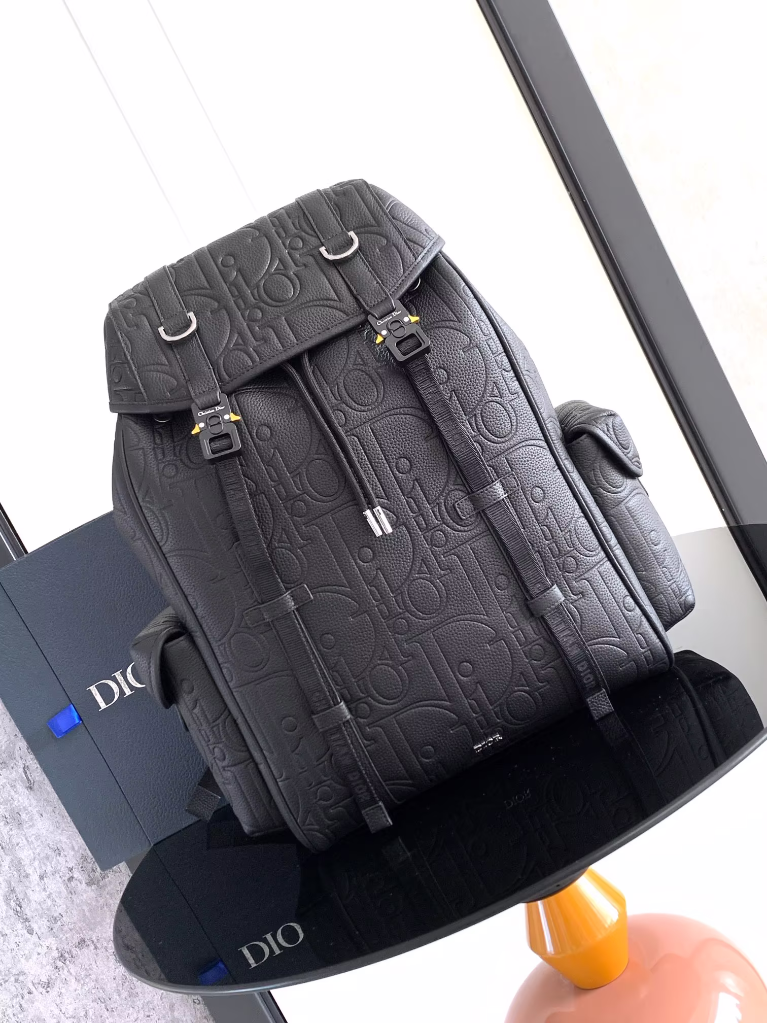 This Dior Hit The Road flap backpack combines contemporary style with the spirit of Dior's couture Dior Gravity print leather is embossed with a classic pattern on black cowhide leather embellished with black grained cowhide leather detailing and the Dior logo on the front to emphasize the craftsmanship of Dior's ateliers. Dior logo jacquard nylon straps, spacious main compartment with flap and two side magnetic flap pockets Practical and versatile, it can be combined with a wide range of casual styles Nylon interior main compartment with flap and drawstring Flat interior computer compartment Side magnetic flap pockets Leather top handles Adjustable padded shoulder straps Aluminum buckle with CD logo and D-rings Padded mesh fabric at back Dior logo on front Metallic cladding Brass Dior logoInterior with Dior embossed logoIncludes dust bagNo. 1ESBA205LLG_H00NSize: 43 x 43 x 18 cm-High-fashion factory