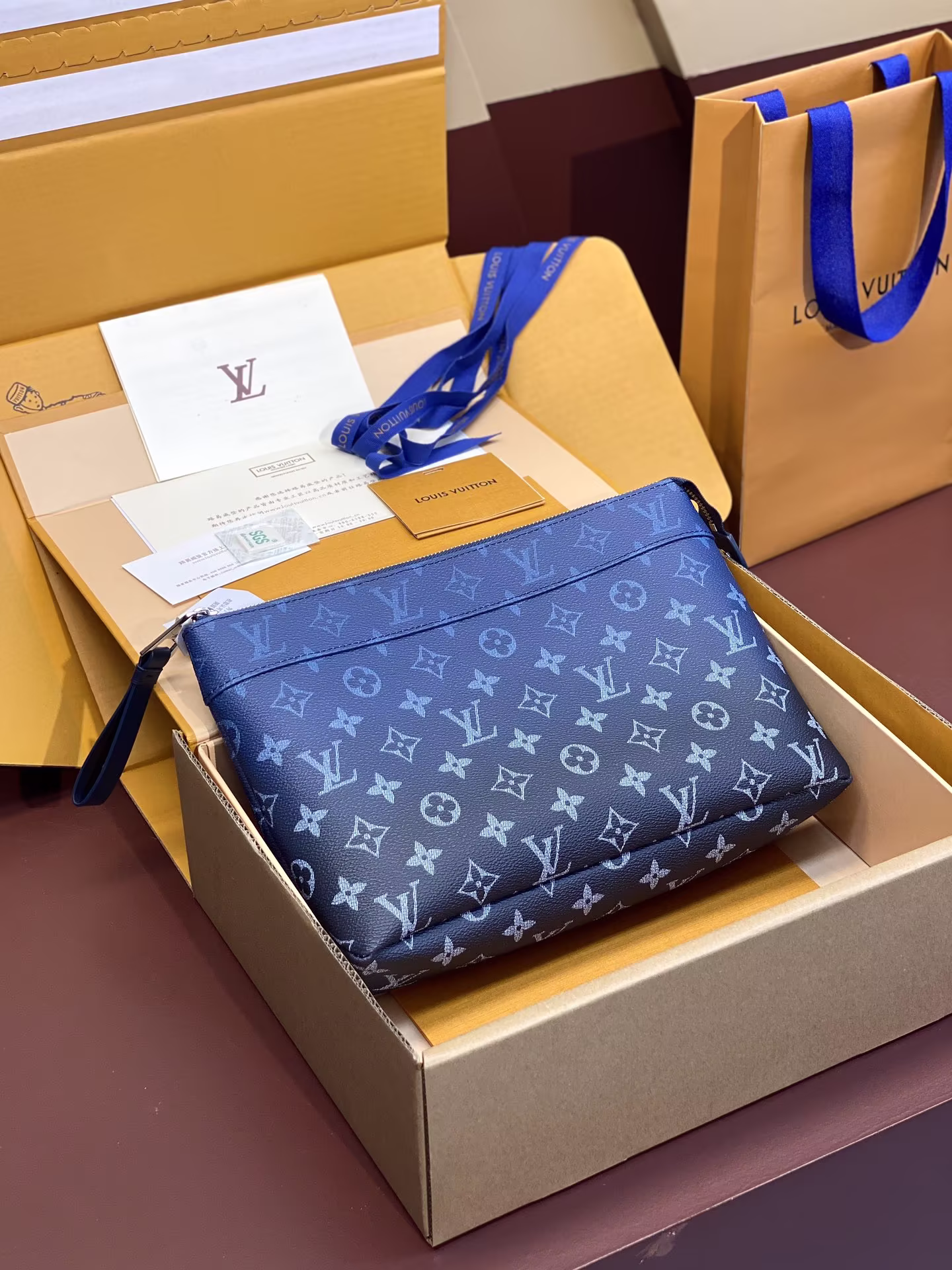 M11545 gradient blue! POCHETTE VOYAGE SOUPLE Clutch The Pochette Voyage Souple Clutch is made of soft Monogram Eclipse coated canvas, with rounded strokes to outline the lines of the classic Pochette Voyage Clutch, bringing a comfortable travel experience. The slim configuration has a zipper compartment and a magnetic buckle back pocket. 32 x 21 x 8 cm (length x height x width) - high imitation bag