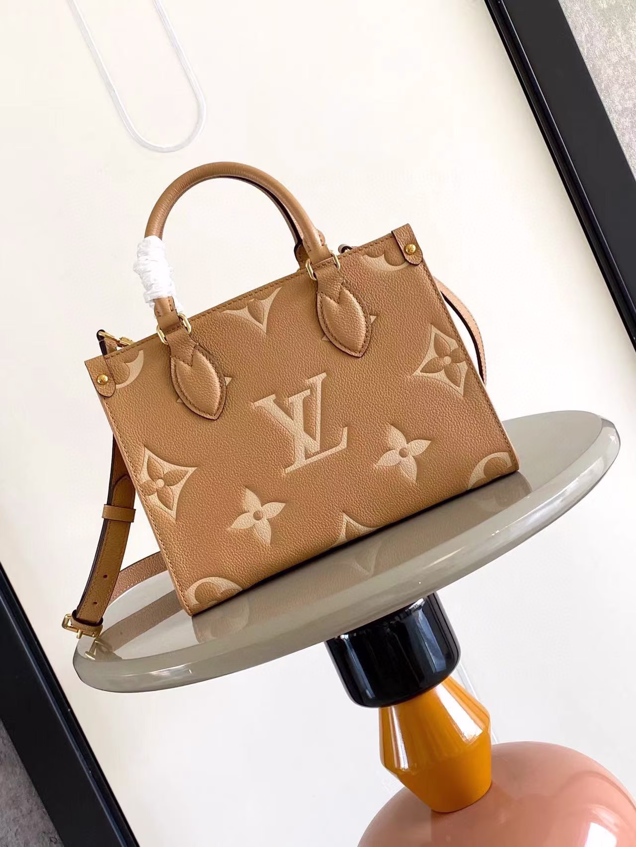 M45654 M45653 This Onthego mini shopping bag will show off the Monogram pattern to the fullest Large letters are embossed on the soft grained cowhide leather Its ample interior can hold a laptop and other office supplies Long and short handles make it easy to carry by hand or over the shoulder Dimensions: 25*19*11.5-High Faux Factory