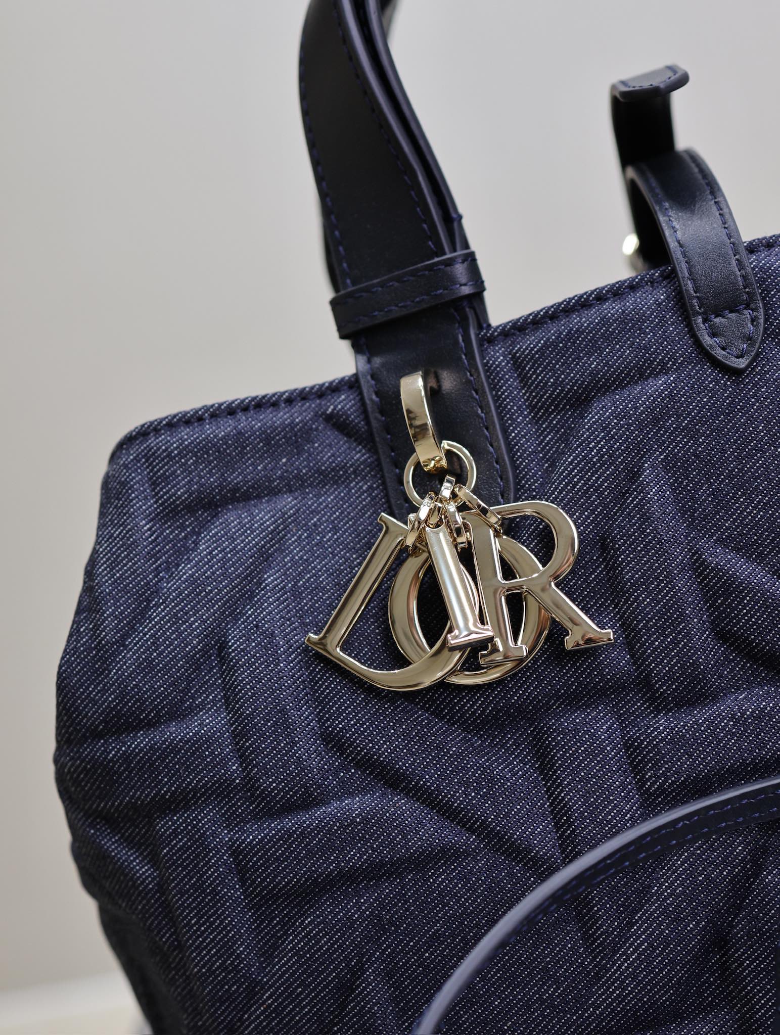 P1460 💯Medium Dior Toujours Handbag "Denim Rattan" This casual and functional Dior Toujours handbag is crafted from blue denim and other materials in a Graphic Rattan pattern and features a stylish 3D version of Dior's iconic pattern. Pockets to neatly organize everyday essentialsSlim leather lace closure to securely store itemsAdditional CD Lock with letter D knob closureAdjustable sides for added styleMedium sizeLeather top handle with adjustable detailsCan be carried on the hand or on the shoulderDouble closure: Slim lace and Christian Dior Paris lace with CD Lock closureD.I.O.R. Detachable charmInterior pouchAdjustable top leather handleModel No.: 1188Size: 28.5 x 21.5 x 17 cm (L x H x W)Holds 2 wallets, 1 cell phone, 2 card holders, sunglasses, and lipstick-High-quality imitation factory