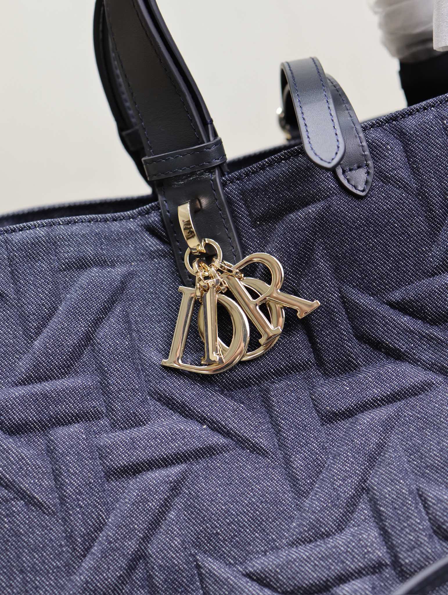 P1520 💯Large Dior Toujours Handbag "Denim Embossed Rattan" This casual and functional Dior Toujours handbag is crafted from blue denim and other materials in a Graphic Rattan pattern and features a sleek, 3D version of Dior's iconic pattern. Pockets to neatly organize everyday essentialsSlim leather lace closure to securely store your belongingsAn additional CD Lock with letter D knob closureAdjustable sides for added styleLarge styleLeather top handles with adjustable detailsCan be carried by hand or over the shoulderDouble closure: Slim lace and Christian Dior Paris lace with CD Lock closureD.I.O.R. Detachable charmInterior pouchAdjustable top leather handleModel No.: 1188Size: 37 x 27 x 19 cm (L x H x W)Spacious enough to store 1 15-inch laptop, 1 clutch, 1 wallet, 1 cell phone, 1 card holder, sunglasses, and lipstick-High-quality imitation factory