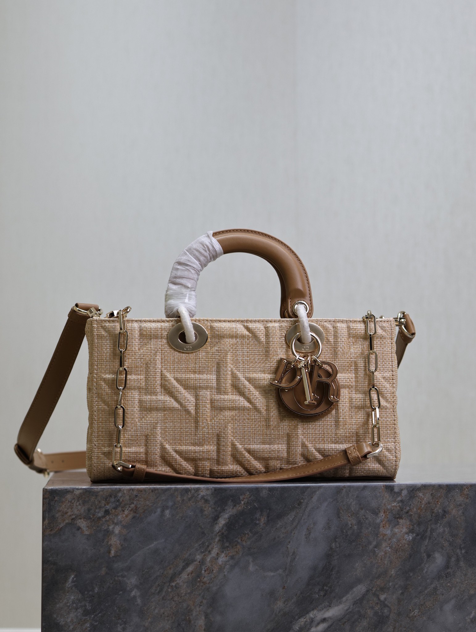 P1340 Medium Lady D-Joy Handbag "Raffia Rattan" This Lady D-Joy handbag highlights the minimalist aesthetic of the Lady Dior collection, which focuses on Dior's profound vision of elegance and beauty, crafted in beige raffia and decorated with a Graphic rattan check pattern in a sleek, 3D version of Dior's iconic motifs in camel leather. D.I.O.R. charm adds a touch of movement to the delicate silhouetteMedium size with detachable chain shoulder strap and adjustable, detachable leather shoulder strapCan be carried by hand, over the shoulder or across the bodyIdeal for everyday stylingDetachable chain shoulder strapAdjustable, detachable leather shoulder strapModel no.: 0613Dimensions: 26 x 13.5 x 5 cm (L x H x W)Holds 1 cell phone, 1 card holder, Sunglasses and Lipstick-High Fake Factory