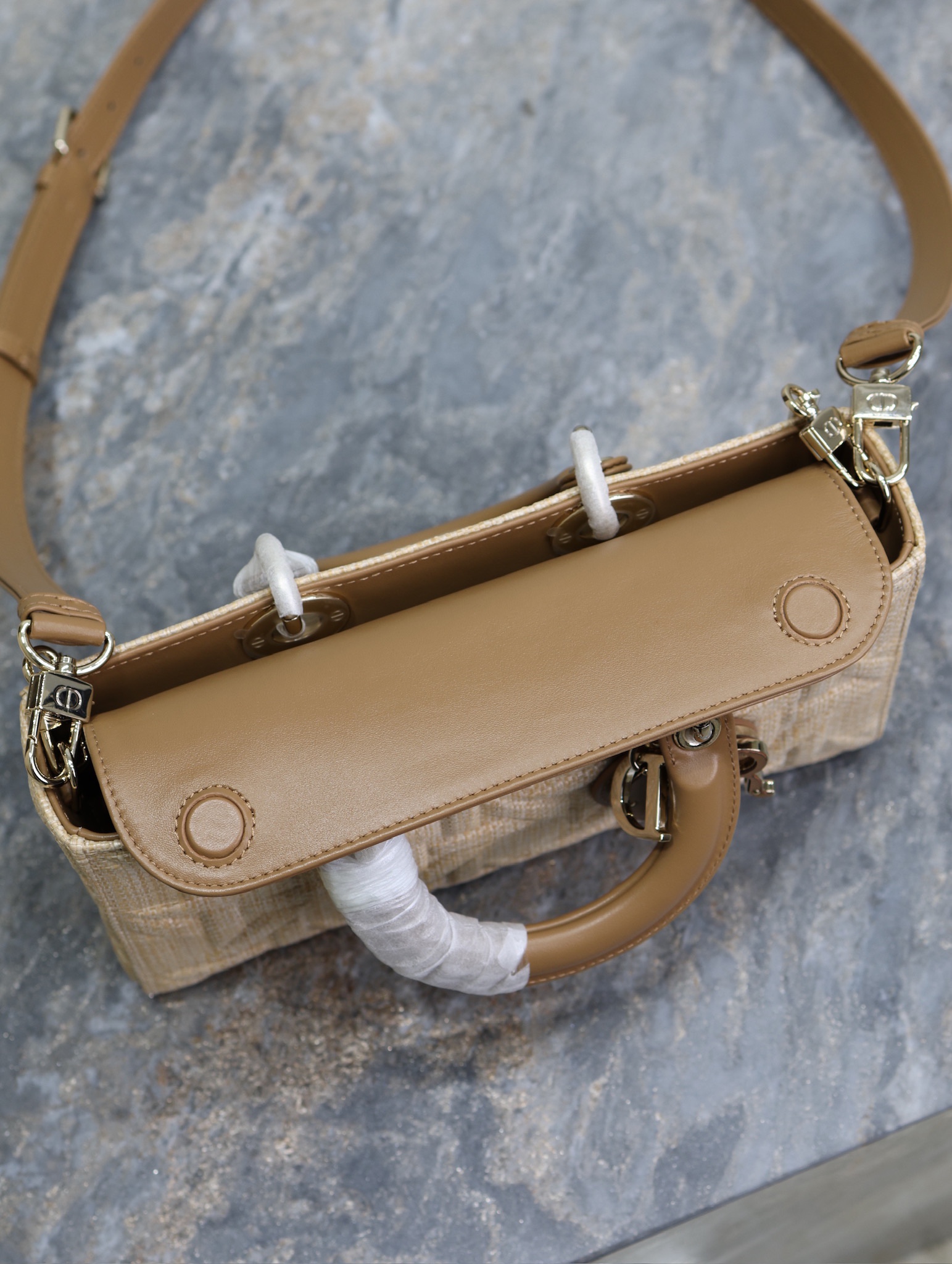 P1340 Medium Lady D-Joy Handbag "Raffia Rattan" This Lady D-Joy handbag highlights the minimalist aesthetic of the Lady Dior collection, which focuses on Dior's profound vision of elegance and beauty, crafted in beige raffia and decorated with a Graphic rattan check pattern in a sleek, 3D version of Dior's iconic motifs in camel leather. D.I.O.R. charm adds a touch of movement to the delicate silhouetteMedium size with detachable chain shoulder strap and adjustable, detachable leather shoulder strapCan be carried by hand, over the shoulder or across the bodyIdeal for everyday stylingDetachable chain shoulder strapAdjustable, detachable leather shoulder strapModel no.: 0613Dimensions: 26 x 13.5 x 5 cm (L x H x W)Holds 1 cell phone, 1 card holder, Sunglasses and Lipstick-High Fake Factory