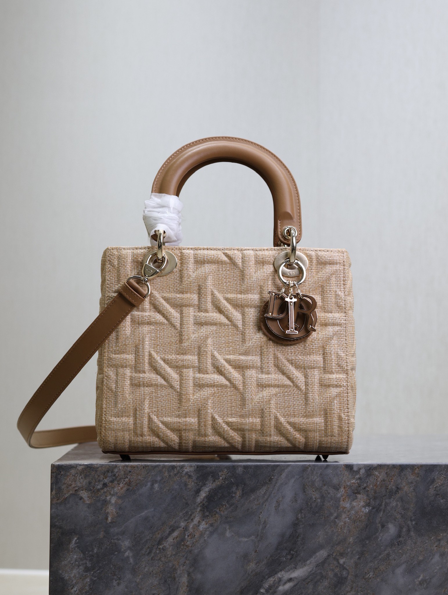 P1380 5-compartment Lady Dior bag "Raffia Rattan Check" This Lady Dior bag highlights the minimalist aesthetic of the Lady Dior collection and focuses on Dior's profound vision of elegance and beauty, crafted in beige raffia and adorned with a Graphic Rattan Check pattern, in a sleek 3D version of Dior's iconic motifs, with a camel leather D.I.O.R. charm that adds a touch of movement to the silhouette. I.O.R. charm adds a touch of movement to the delicate silhouetteMedium size with adjustable, detachable leather shoulder strapCan be carried by hand, over the shoulder or across the bodyIdeal for everyday stylingAdjustable, detachable leather shoulder strapModel No.: 0565Measurements: 24 x 20 x 11 cm (L x H x W)-High-Fashion Factory