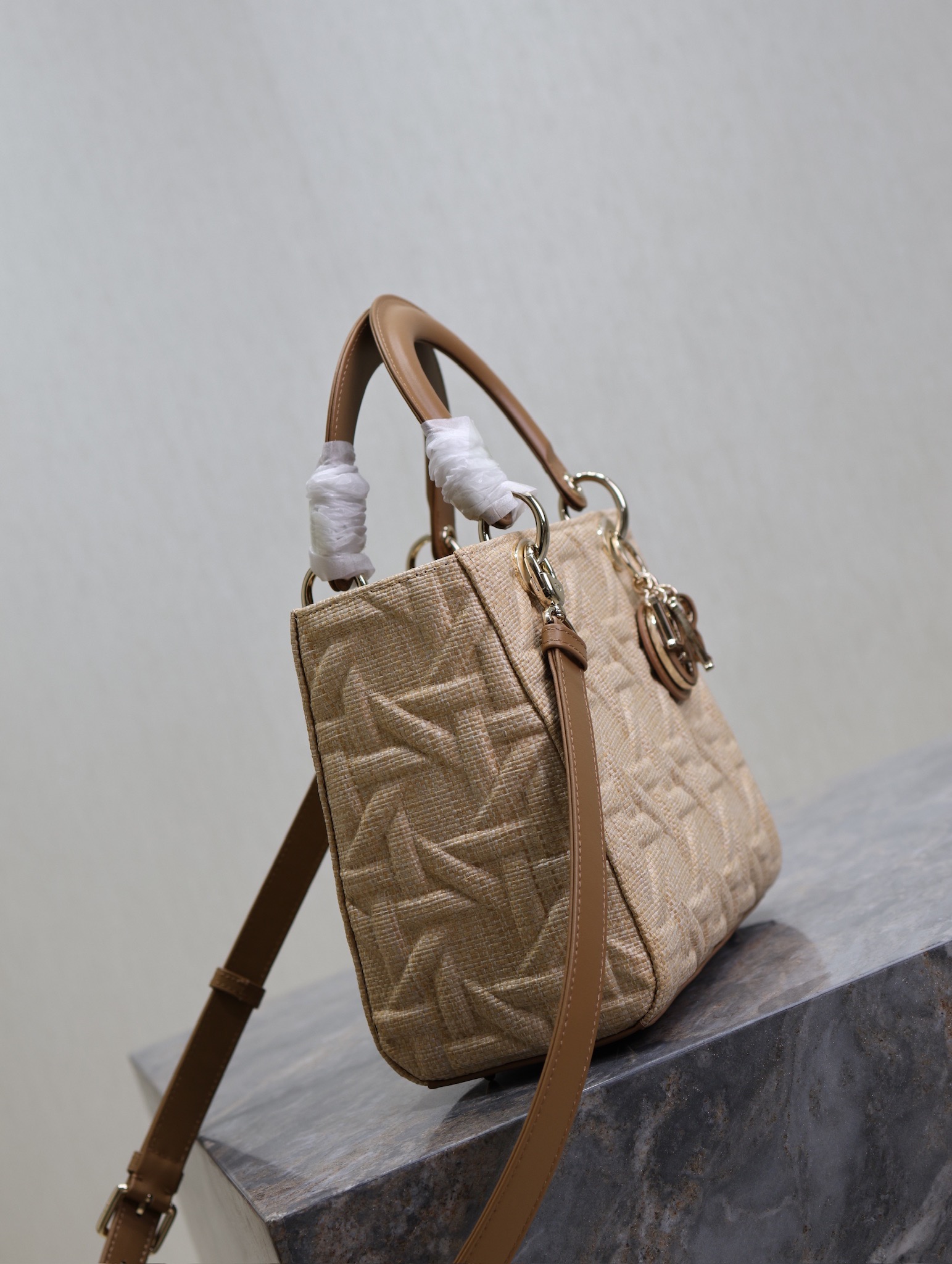 P1380 5-compartment Lady Dior bag "Raffia Rattan Check" This Lady Dior bag highlights the minimalist aesthetic of the Lady Dior collection and focuses on Dior's profound vision of elegance and beauty, crafted in beige raffia and adorned with a Graphic Rattan Check pattern, in a sleek 3D version of Dior's iconic motifs, with a camel leather D.I.O.R. charm that adds a touch of movement to the silhouette. I.O.R. charm adds a touch of movement to the delicate silhouetteMedium size with adjustable, detachable leather shoulder strapCan be carried by hand, over the shoulder or across the bodyIdeal for everyday stylingAdjustable, detachable leather shoulder strapModel No.: 0565Measurements: 24 x 20 x 11 cm (L x H x W)-High-Fashion Factory