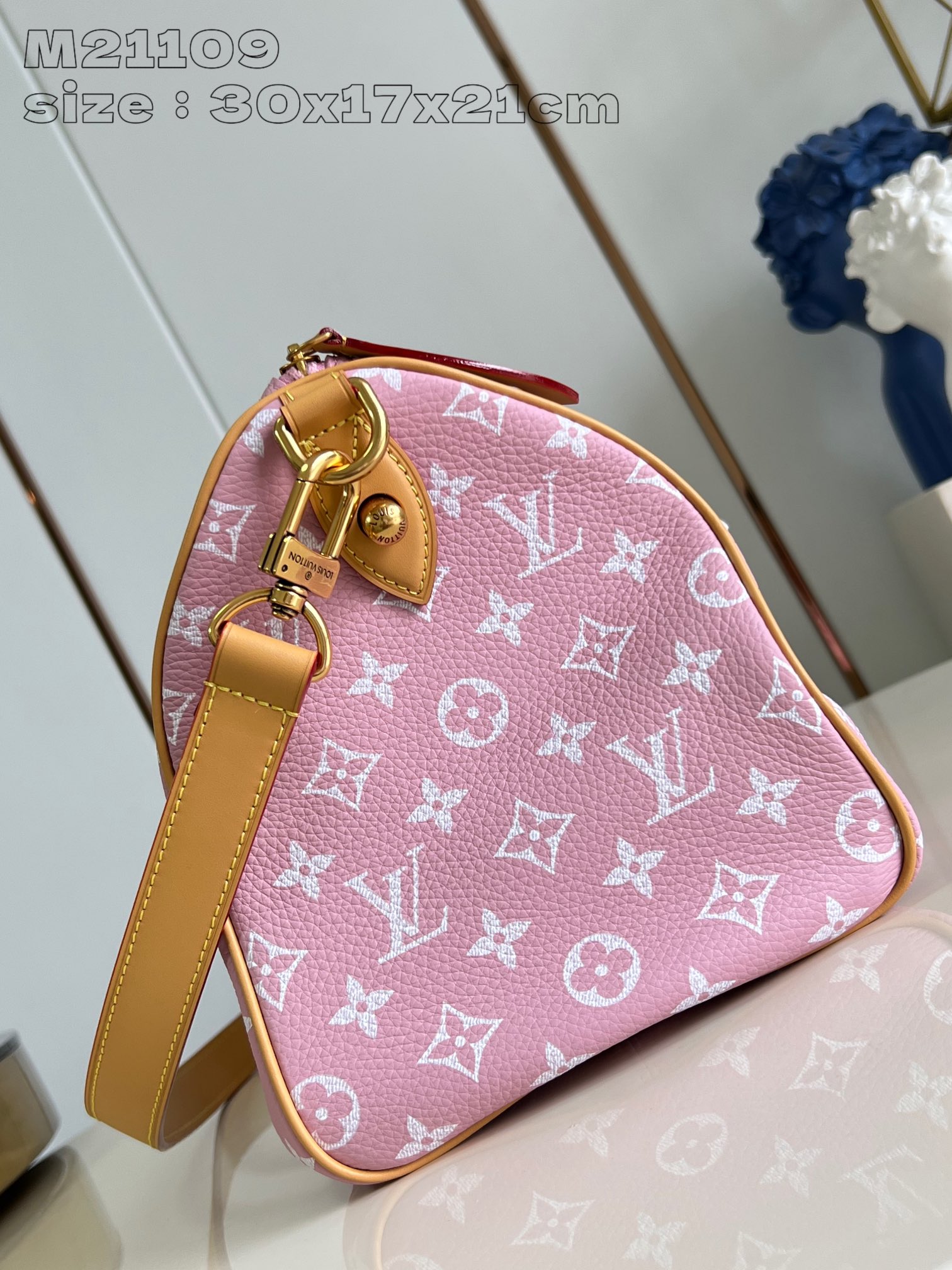 P2600 M21109 Pink Leather The Speedy P18 Bandoulière 30 Monogram Leather Handbag delivers an opulent texture in supple cowhide leather with a Monogram print that mirrors the Monogram elements on the canvas. Polished metal hardware, sheepskin leather lining and built-in tag highlight Creative Director Pharrell Williams' attention to detail. Dimensions: 30 x 17 x 21 cm (L x H x W)