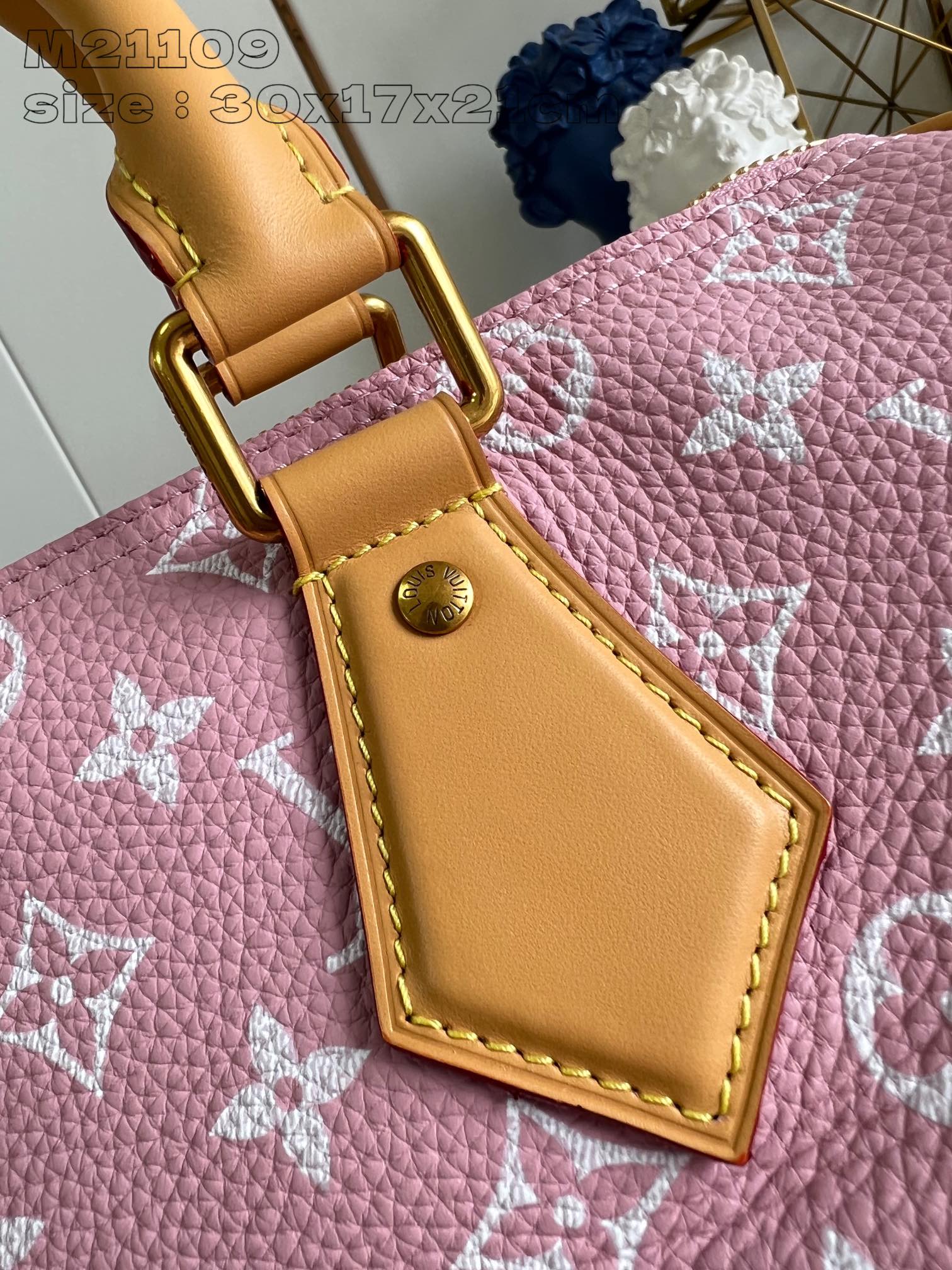 P2600 M21109 Pink Leather The Speedy P18 Bandoulière 30 Monogram Leather Handbag delivers an opulent texture in supple cowhide leather with a Monogram print that mirrors the Monogram elements on the canvas. Polished metal hardware, sheepskin leather lining and built-in tag highlight Creative Director Pharrell Williams' attention to detail. Dimensions: 30 x 17 x 21 cm (L x H x W)