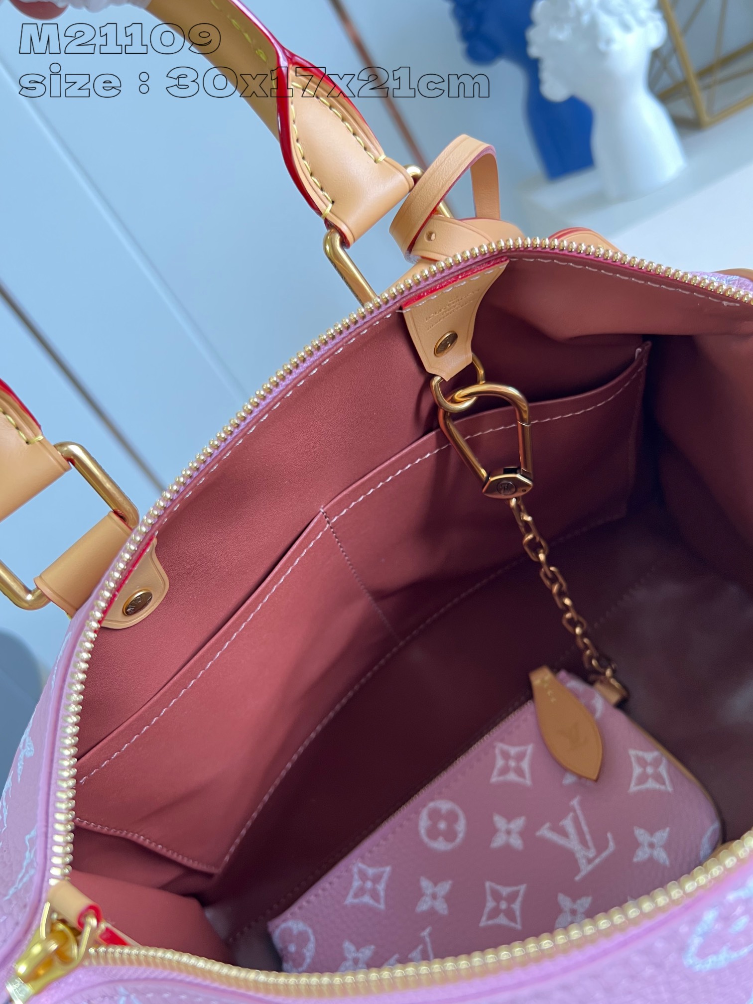P2600 M21109 Pink Leather The Speedy P18 Bandoulière 30 Monogram Leather Handbag delivers an opulent texture in supple cowhide leather with a Monogram print that mirrors the Monogram elements on the canvas. Polished metal hardware, sheepskin leather lining and built-in tag highlight Creative Director Pharrell Williams' attention to detail. Dimensions: 30 x 17 x 21 cm (L x H x W)