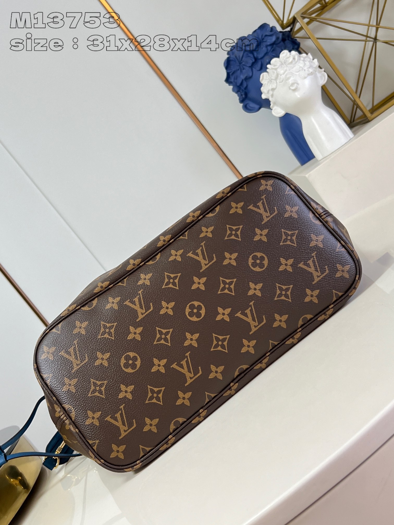 P1200 M13753Blue This reversible Neverfull medium tote bag is made of soft Monogram canvas outlined with cowhide trimmings in a spacious configuration with a colorful fabric lining and two side straps that can be cinched or unfolded for a distinctive look Slim handles for carrying on the shoulder or elbow Detachable zipper pocket can be used as a clutch or as a pocket 31 x 28 x 14 cm (L x H x W)