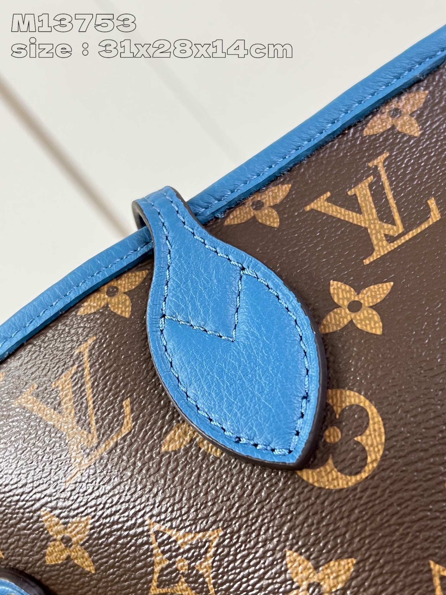 P1200 M13753Blue This reversible Neverfull medium tote bag is made of soft Monogram canvas outlined with cowhide trimmings in a spacious configuration with a colorful fabric lining and two side straps that can be cinched or unfolded for a distinctive look Slim handles for carrying on the shoulder or elbow Detachable zipper pocket can be used as a clutch or as a pocket 31 x 28 x 14 cm (L x H x W)