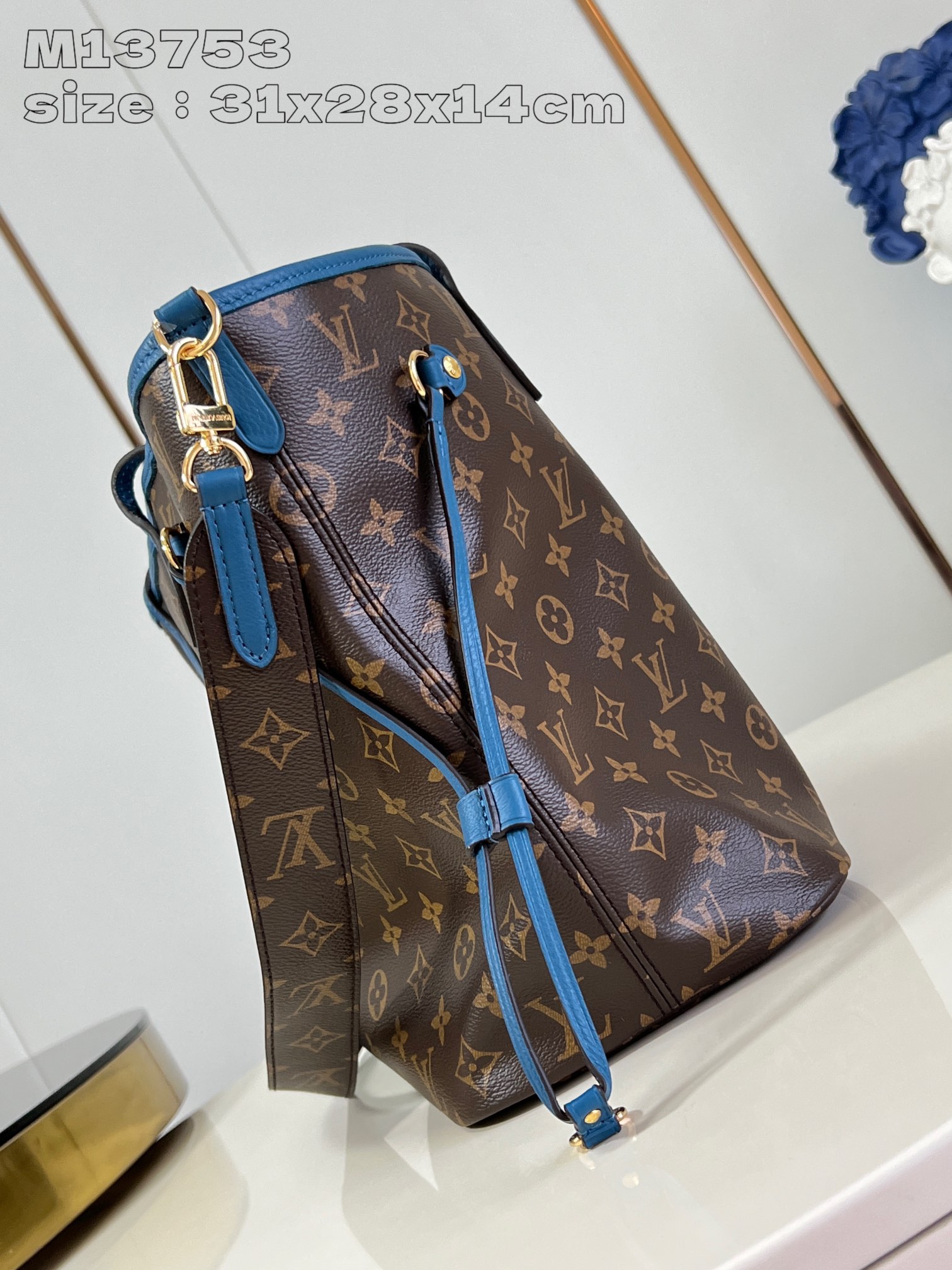 P1200 M13753Blue This reversible Neverfull medium tote bag is made of soft Monogram canvas outlined with cowhide trimmings in a spacious configuration with a colorful fabric lining and two side straps that can be cinched or unfolded for a distinctive look Slim handles for carrying on the shoulder or elbow Detachable zipper pocket can be used as a clutch or as a pocket 31 x 28 x 14 cm (L x H x W)