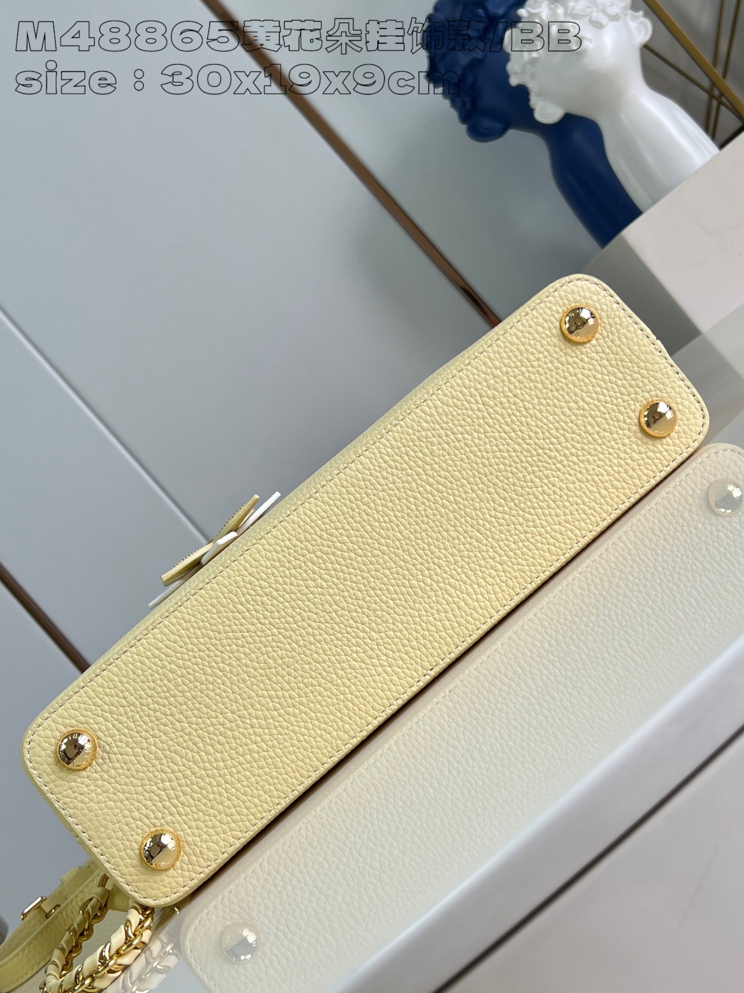 P2400 M48865 Yellow Flower Charm/Small This medium Capucines East-West bag is made from grained cowhide leather that gives a chic luster to metal pieces such as the octagonal chain links. The detachable Arty chain illuminates the long, slender silhouette and the interior features a zippered pocket and a patch pocket. 30 x 19 x 9 cm (L x H x W).