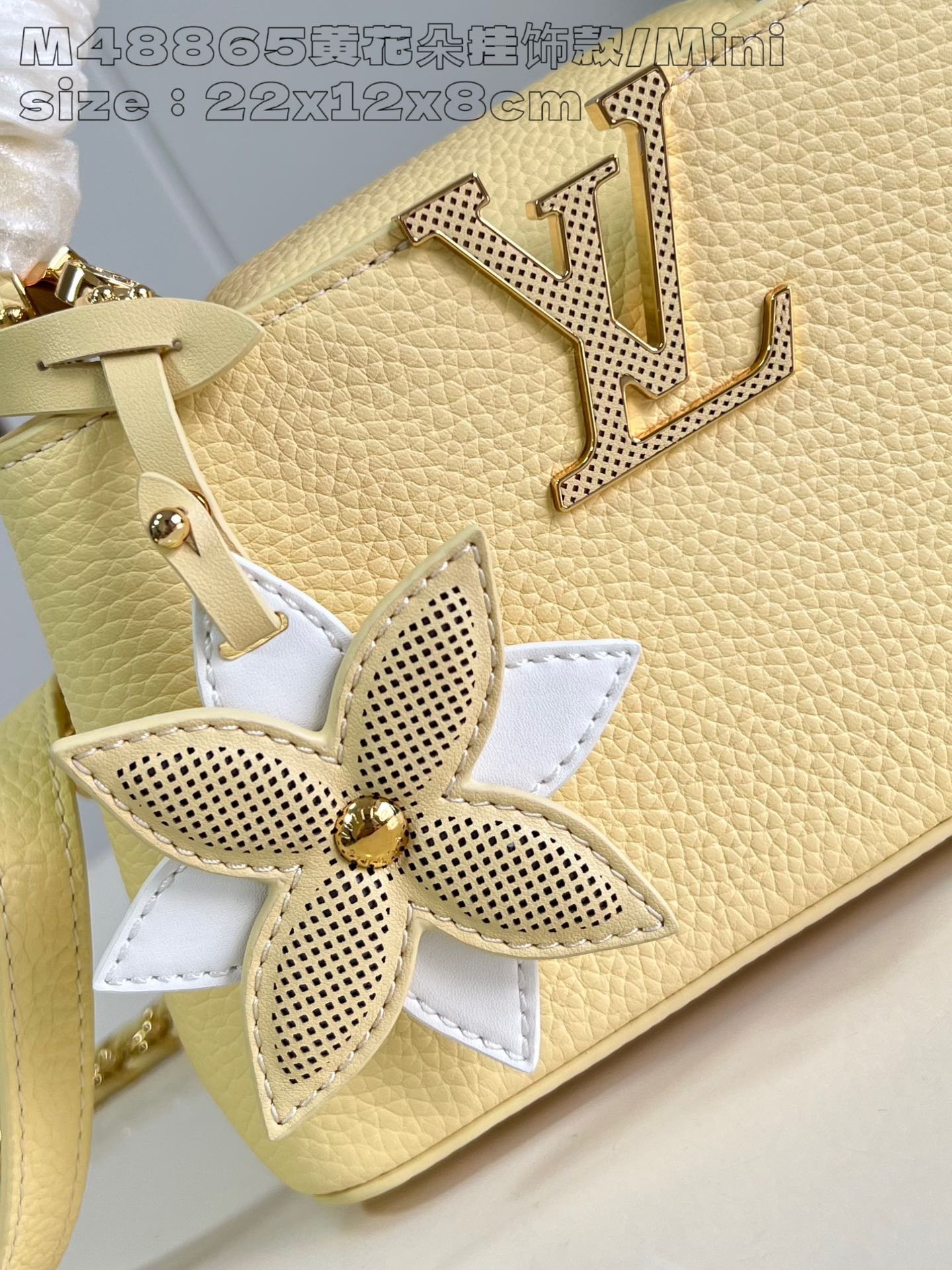 P2200 M8865 Yellow Flower Charm/Mini M11351 This Capucines East-West mini bag in Taurillon cowhide leather is rendered in the bright hues of a late summer afternoon and finished with a detachable Monogram floral leather trim for a touch of spunky interest. 22 x 12 x 8 cm (L x H x W) N
