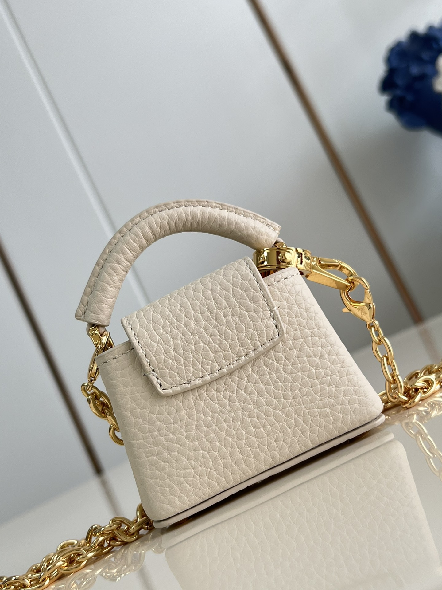 M48865 Super mini Chain Bag M02132 This adorable Micro Bag Capucines is a miniature reinterpretation of the legendary Louis Vuitton handbag design in richly textured cowhide leather with a gold metal LV logo clasp embellished with luxurious logo detailing and a convenient Monogram floral clasp that echoes the design. Ideal for carrying headphones or other small items, it can also be used as a shoulder bag.