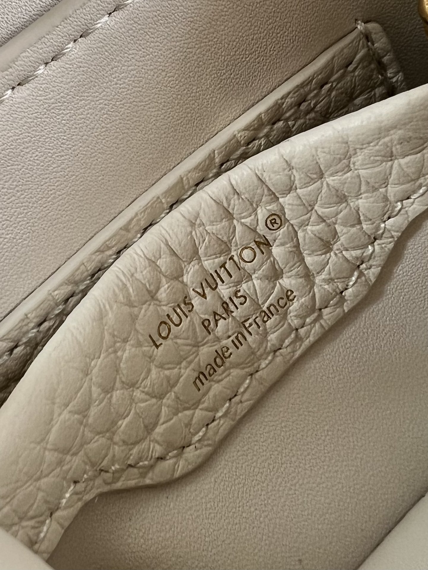 M48865 Super mini Chain Bag M02132 This adorable Micro Bag Capucines is a miniature reinterpretation of the legendary Louis Vuitton handbag design in richly textured cowhide leather with a gold metal LV logo clasp embellished with luxurious logo detailing and a convenient Monogram floral clasp that echoes the design. Ideal for carrying headphones or other small items, it can also be used as a shoulder bag.