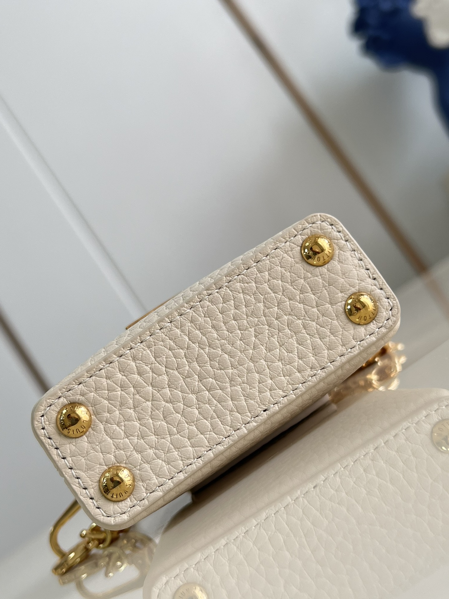 M48865 Super mini Chain Bag M02132 This adorable Micro Bag Capucines is a miniature reinterpretation of the legendary Louis Vuitton handbag design in richly textured cowhide leather with a gold metal LV logo clasp embellished with luxurious logo detailing and a convenient Monogram floral clasp that echoes the design. Ideal for carrying headphones or other small items, it can also be used as a shoulder bag.