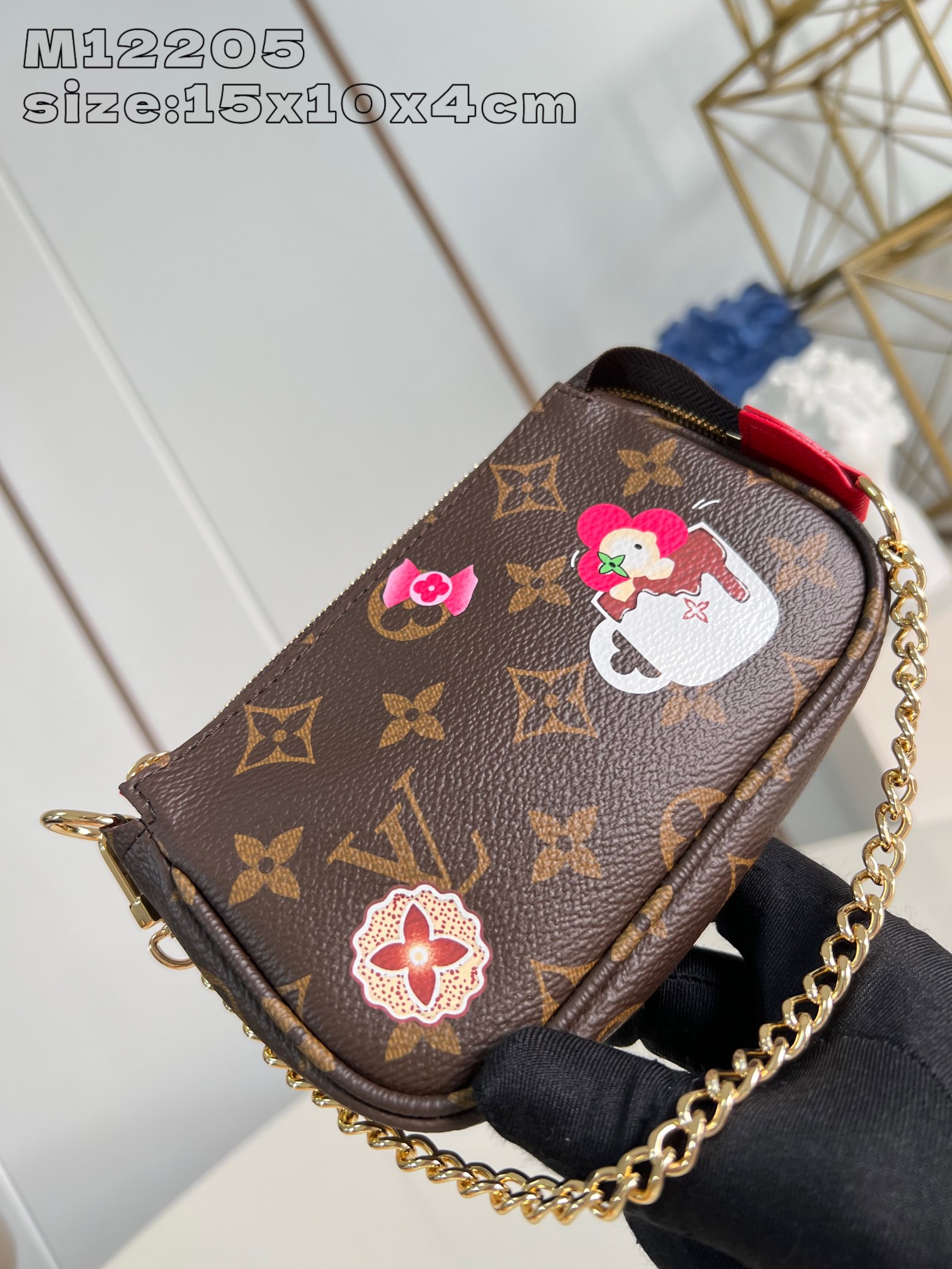 M12205 這款Candy Factory系列的Mini Pochette Accessoires充滿節日氣息綴有經典Vivienne玩偶在熱巧十克力杯內浸浴等可愛圖案設計以路易威登的標誌性Monogram帆布打造飾以鮮豔的Candy紅色襯裡並配上金色鉤扣鏈帶及Vivienne形狀拉鏈設計15.5 x 10.5 x 4 厘米 (長度 x 高度 x 闊度）-高仿包包