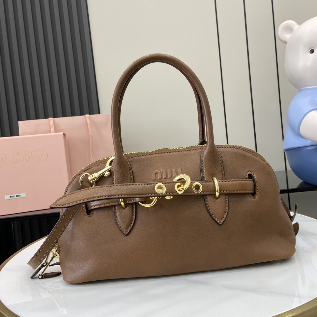 p2080 MiuMiu新品保龄球包釆用顶级复古植柔羊皮复古磨砂感做旧金属配件这款Aventure Nappa 皮革手提包灵感源自 MiuMiu典藏单品其结构经过调整变得更加轻便焕发全新个性打造具有隽永魅力的经典包款多元素的设计赋予这款手提包独特美感和经典气息可拆卸可调节皮革肩带帆布内里配拉链口袋和贴袋
型号：5bb168
尺寸：33（长）x 16.5（宽）x 10cm（厚）
颜色：棕色/-高仿包包