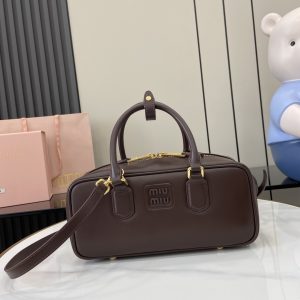 p1720 miumiu缪缪Arcadie 牛皮革中号(27cm)保龄球手提包/斜挎包～干邑色牛皮
这款Arcadic手袋彰显独特的理念即时装是对现实的反映转译为物质形态的工具与金属五金配件的饰面相辉映的字母徽标精致做工卓尔不凡彰显极具辨识度的经典格调动感优雅线条搭配可调式可拆卸肩带呈现富有现代魅力的实用百搭设计
可拆卸可调式肩带
拉链开合
正面涂漆金属字母徽标
带衬里配拉链口袋
配脚钉
型号：5BB148
尺寸：27（长）x 12（宽）x 9cm（厚）
颜色：酒红色/-高仿包包