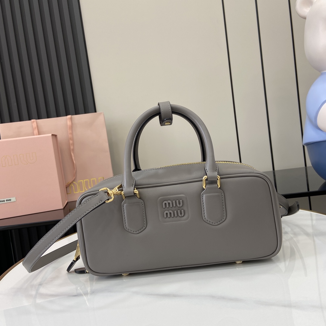 p1720 miumiu miu Arcadie Cowhide Medium (27cm) Bowling Tote/Crossbody ~ Cognac Cowhide This Arcadic handbag highlights the unique concept that fashion is a reflection of reality translated into material form with a metal hardware finish mirroring the monogrammed logo exquisite workmanship extraordinary highlights the recognizable classic style dynamic and elegant lines With adjustable detachable shoulder strap presents a practical and versatile design with modern appealDetachable adjustable shoulder strap with zipper closurePainted metal letter logo on front with lining and zipper pocket with studsModel No.: 5BB148Size: 27 (L) x 12 (W) x 9cm (Thick)Color: Grey/-High quality imitation factory