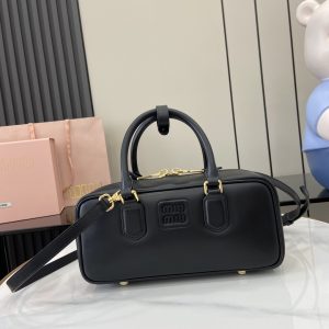 p1720 miumiu缪缪Arcadie 牛皮革中号(27cm)保龄球手提包/斜挎包～干邑色牛皮
这款Arcadic手袋彰显独特的理念即时装是对现实的反映转译为物质形态的工具与金属五金配件的饰面相辉映的字母徽标精致做工卓尔不凡彰显极具辨识度的经典格调动感优雅线条搭配可调式可拆卸肩带呈现富有现代魅力的实用百搭设计
可拆卸可调式肩带
拉链开合
正面涂漆金属字母徽标
带衬里配拉链口袋
配脚钉
型号：5BB148
尺寸：27（长）x 12（宽）x 9cm（厚）
颜色：黑色/-高仿包包