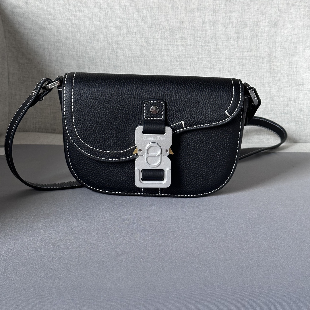 This saddle flap messenger bag is a sleek design with a flap for sophisticated elegance that elevates the saddle collection. Crafted in black grained cowhide with contrasting stitching, the saddle flap is embellished with the Christian Dior logo and an aluminum buckle. The miniature style is finished with a detachable, adjustable leather shoulder strap that can be carried in a handheld, over the shoulder, or crossbody.Nylon lined interior slit pocketMagnetic patch pocket at backModel number 8025Size 19.5-13-4.3Detachable, adjustable leather shoulder strapDior logo embossed on insideInterior dust bag19170960
