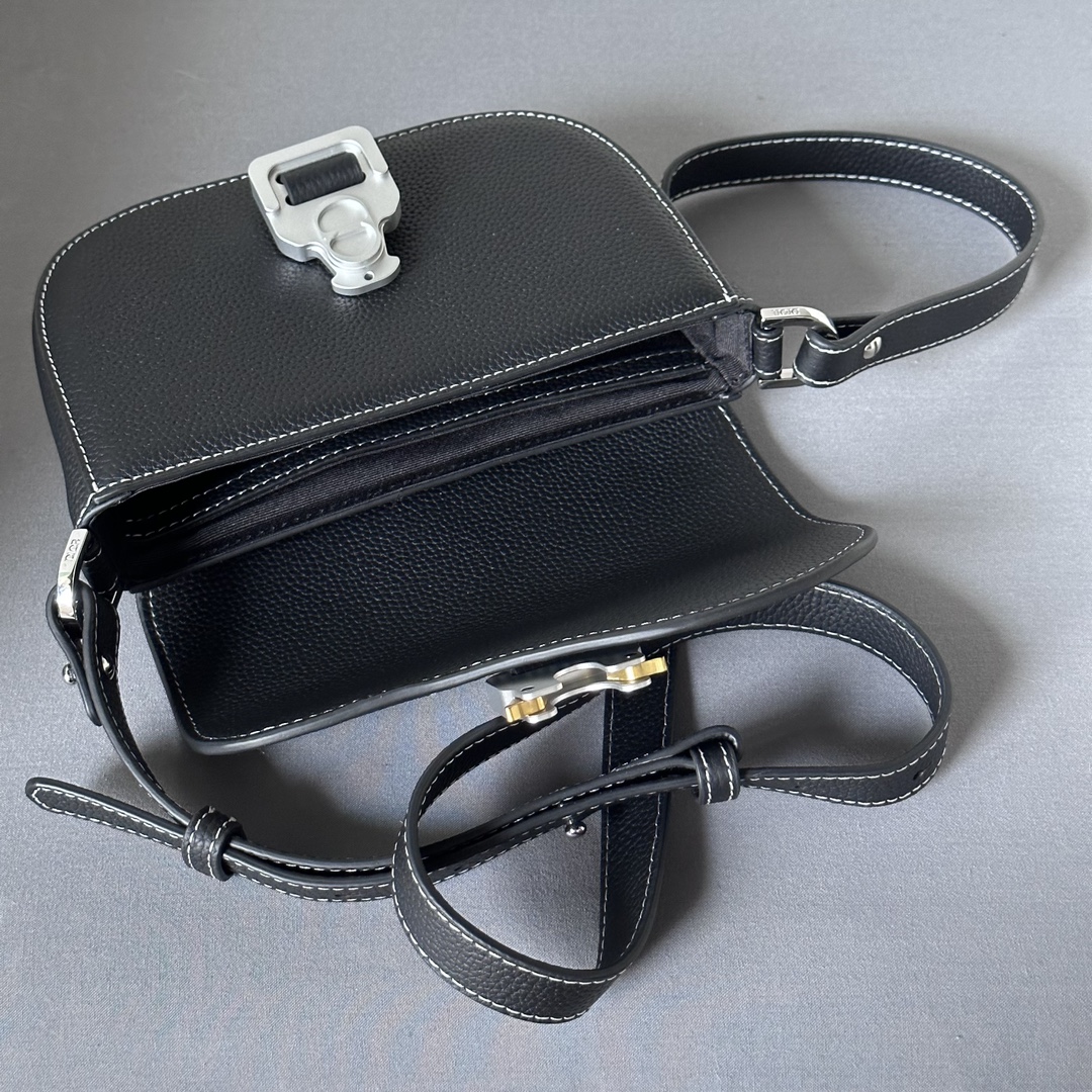 This saddle flap messenger bag is a sleek design with a flap for sophisticated elegance that elevates the saddle collection. Crafted in black grained cowhide with contrasting stitching, the saddle flap is embellished with the Christian Dior logo and an aluminum buckle. The miniature style is finished with a detachable, adjustable leather shoulder strap that can be carried in a handheld, over the shoulder, or crossbody.Nylon lined interior slit pocketMagnetic patch pocket at backModel number 8025Size 19.5-13-4.3Detachable, adjustable leather shoulder strapDior logo embossed on insideInterior dust bag19170960