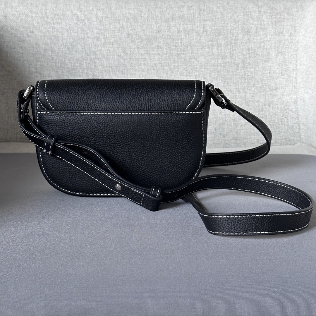 This saddle flap messenger bag is a sleek design with a flap for sophisticated elegance that elevates the saddle collection. Crafted in black grained cowhide with contrasting stitching, the saddle flap is embellished with the Christian Dior logo and an aluminum buckle. The miniature style is finished with a detachable, adjustable leather shoulder strap that can be carried in a handheld, over the shoulder, or crossbody.Nylon lined interior slit pocketMagnetic patch pocket at backModel number 8025Size 19.5-13-4.3Detachable, adjustable leather shoulder strapDior logo embossed on insideInterior dust bag19170960