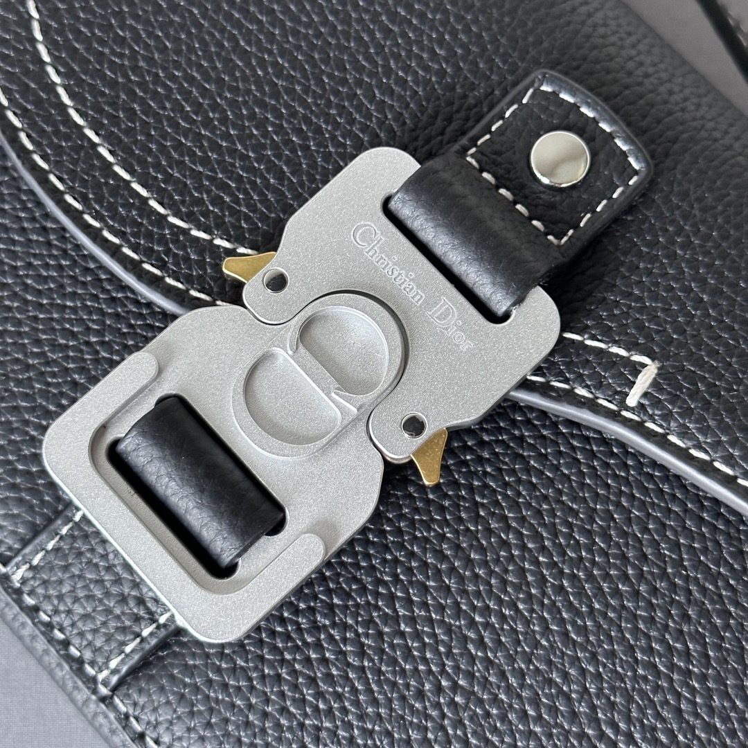 This saddle flap messenger bag is a sleek design with a flap for sophisticated elegance that elevates the saddle collection. Crafted in black grained cowhide with contrasting stitching, the saddle flap is embellished with the Christian Dior logo and an aluminum buckle. The miniature style is finished with a detachable, adjustable leather shoulder strap that can be carried in a handheld, over the shoulder, or crossbody.Nylon lined interior slit pocketMagnetic patch pocket at backModel number 8025Size 19.5-13-4.3Detachable, adjustable leather shoulder strapDior logo embossed on insideInterior dust bag19170960