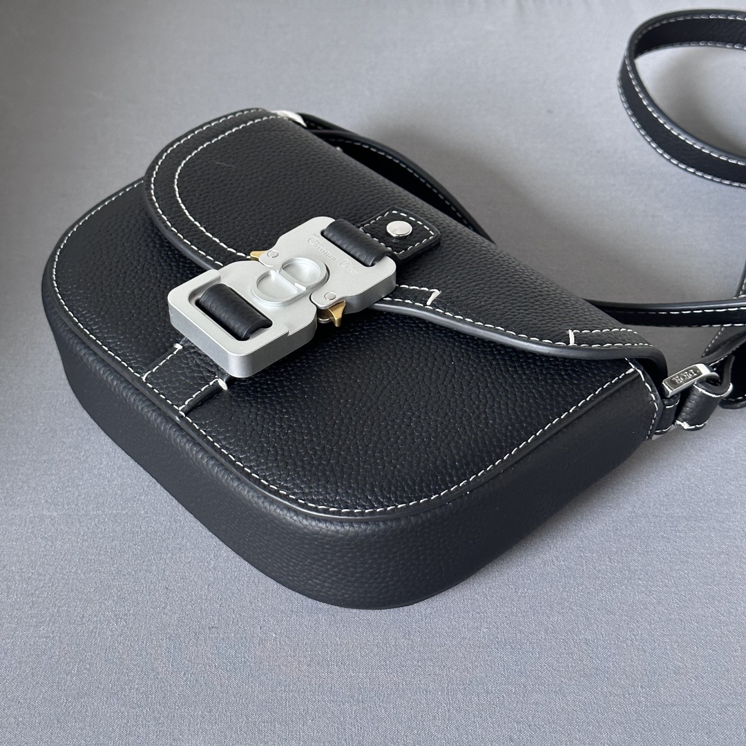 This saddle flap messenger bag is a sleek design with a flap for sophisticated elegance that elevates the saddle collection. Crafted in black grained cowhide with contrasting stitching, the saddle flap is embellished with the Christian Dior logo and an aluminum buckle. The miniature style is finished with a detachable, adjustable leather shoulder strap that can be carried in a handheld, over the shoulder, or crossbody.Nylon lined interior slit pocketMagnetic patch pocket at backModel number 8025Size 19.5-13-4.3Detachable, adjustable leather shoulder strapDior logo embossed on insideInterior dust bag19170960
