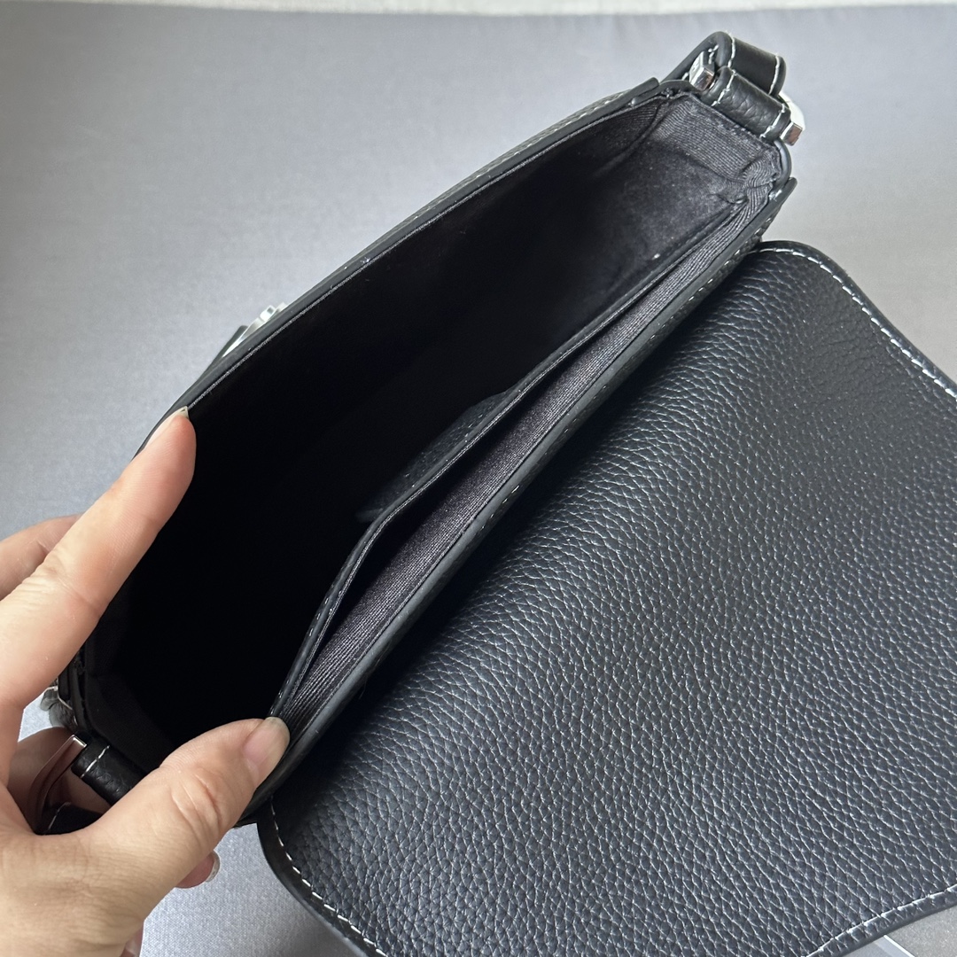 This saddle flap messenger bag is a sleek design with a flap for sophisticated elegance that elevates the saddle collection. Crafted in black grained cowhide with contrasting stitching, the saddle flap is embellished with the Christian Dior logo and an aluminum buckle. The miniature style is finished with a detachable, adjustable leather shoulder strap that can be carried in a handheld, over the shoulder, or crossbody.Nylon lined interior slit pocketMagnetic patch pocket at backModel number 8025Size 19.5-13-4.3Detachable, adjustable leather shoulder strapDior logo embossed on insideInterior dust bag19170960